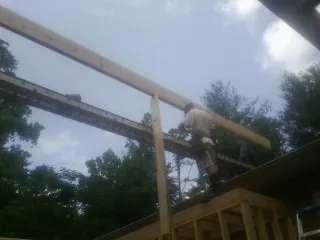 Carpenter setting a ridge beam over a new addition frame — Ice Dam Removal by Roofing Brothers in Oxford